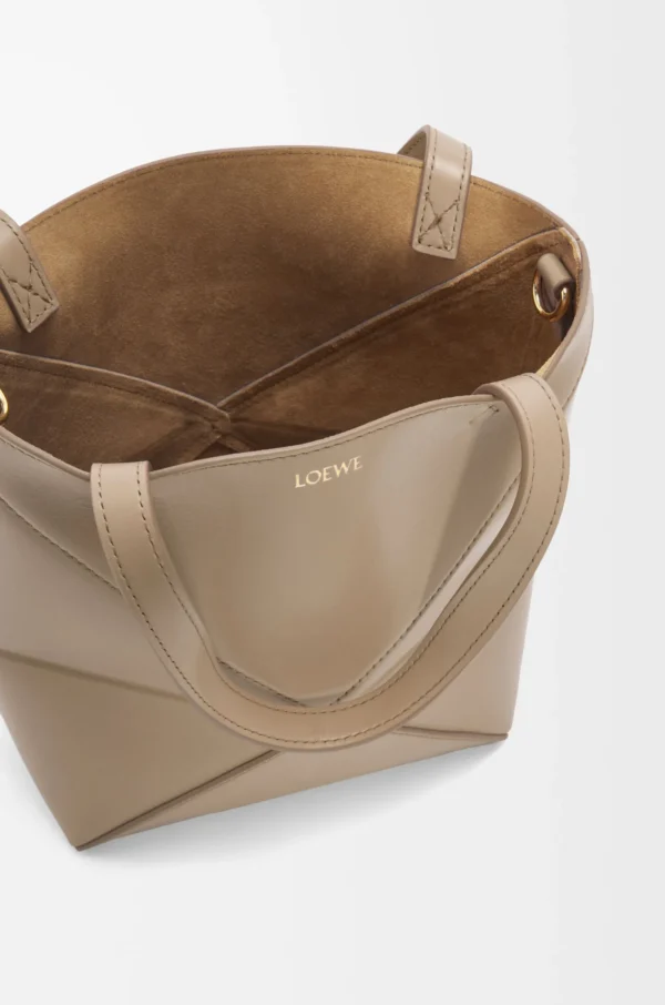 7724596c80277d1c029413ea685fc792-scaled-1.webp Mini Puzzle Fold tote in shiny calfskin